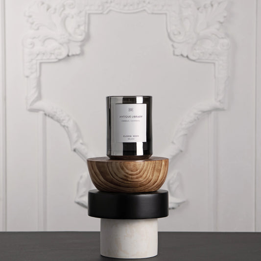 Cloon Keen Luxury Scented Candle - Hand Poured Irish Candle displayed in a stylish glass vessel on decorative wooden bases.