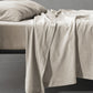 Society Limonta Smir flat sheet in Mastice beige draping over a bed, highlighting the warm, soft-washed winter texture.