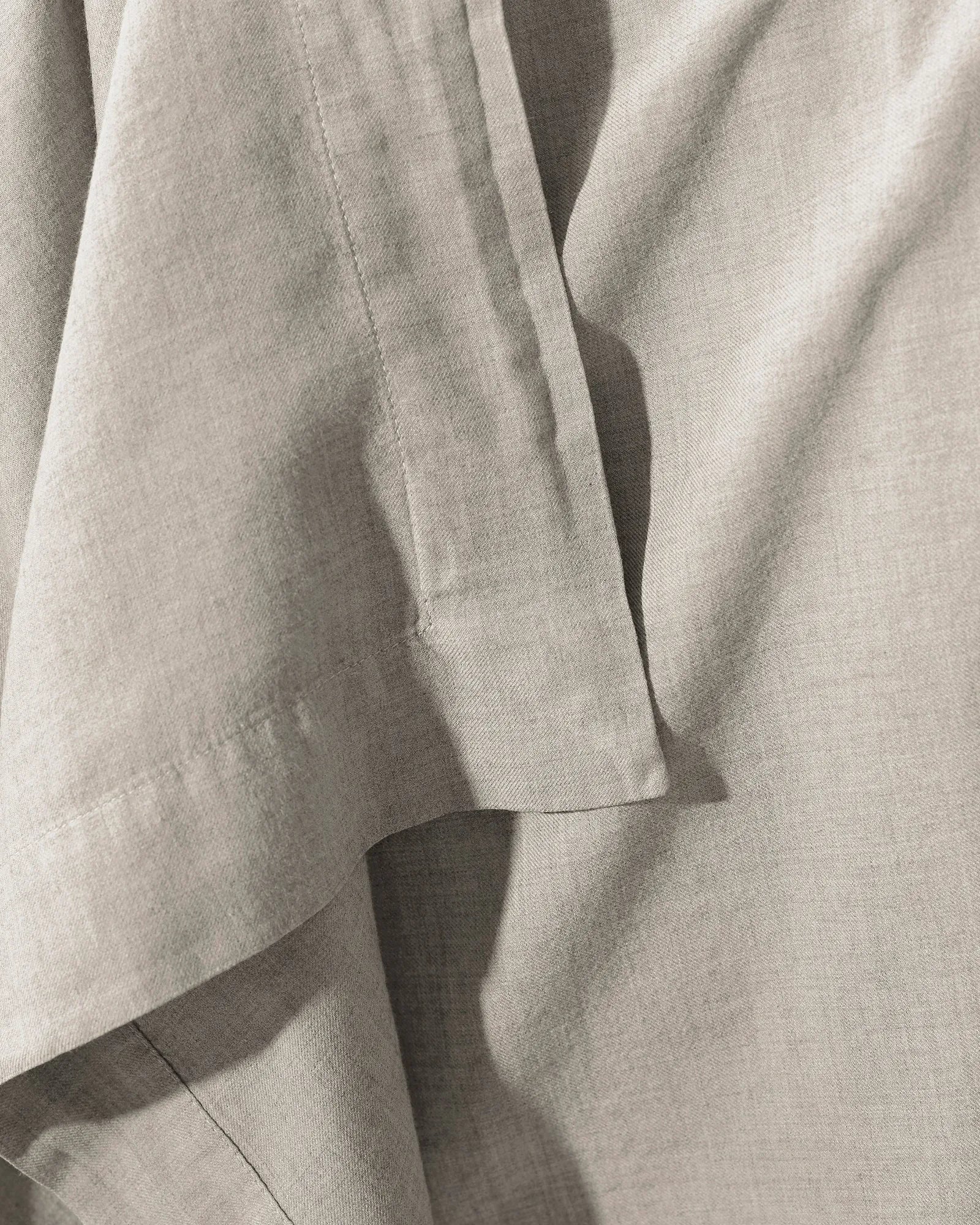 Detail view of the soft hem and warm texture of the Smir flat sheet in a light garment-dyed finish.