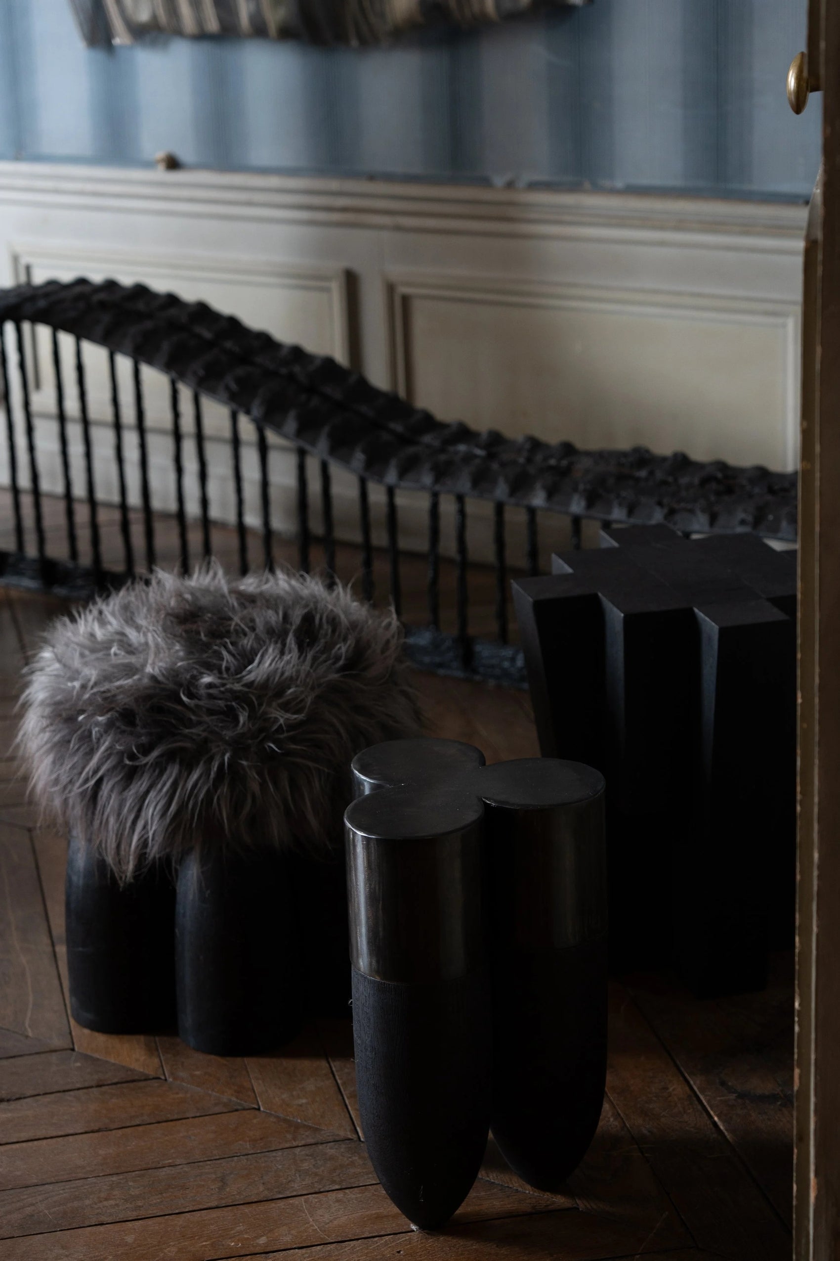 Senufo Ottoman featuring Black African Walnut and Sheep Wool, designed by Arno DeClercq in a stylish interior setting.