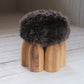 Senufo Ottoman designed by Arno DeClercq featuring a wool seat and Black African Walnut legs