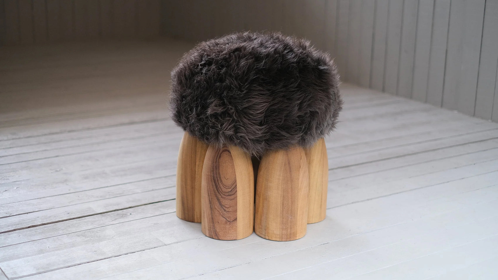 Senufo Ottoman designed by Arno DeClercq featuring a wool seat and Black African Walnut legs