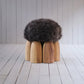 Senufo Ottoman by Arno DeClercq, featuring a Sheep Wool seat on a Black African Walnut base.