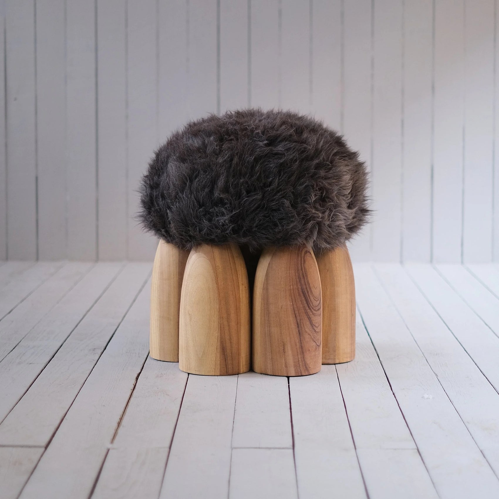 Senufo Ottoman by Arno DeClercq, featuring a Sheep Wool seat on a Black African Walnut base.