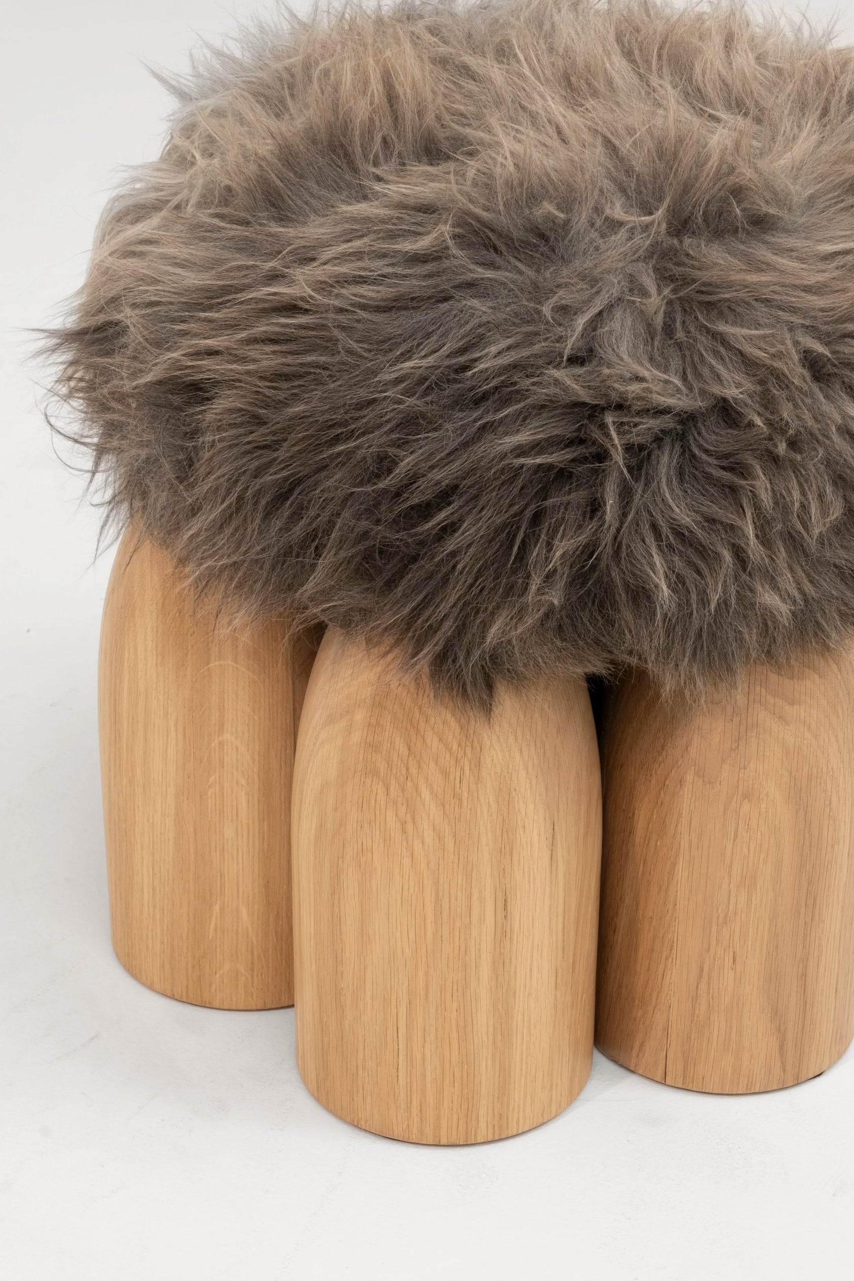 Senufo Ottoman designed by Arno DeClercq featuring rounded legs in French Oak and Sheep Wool upholstery.