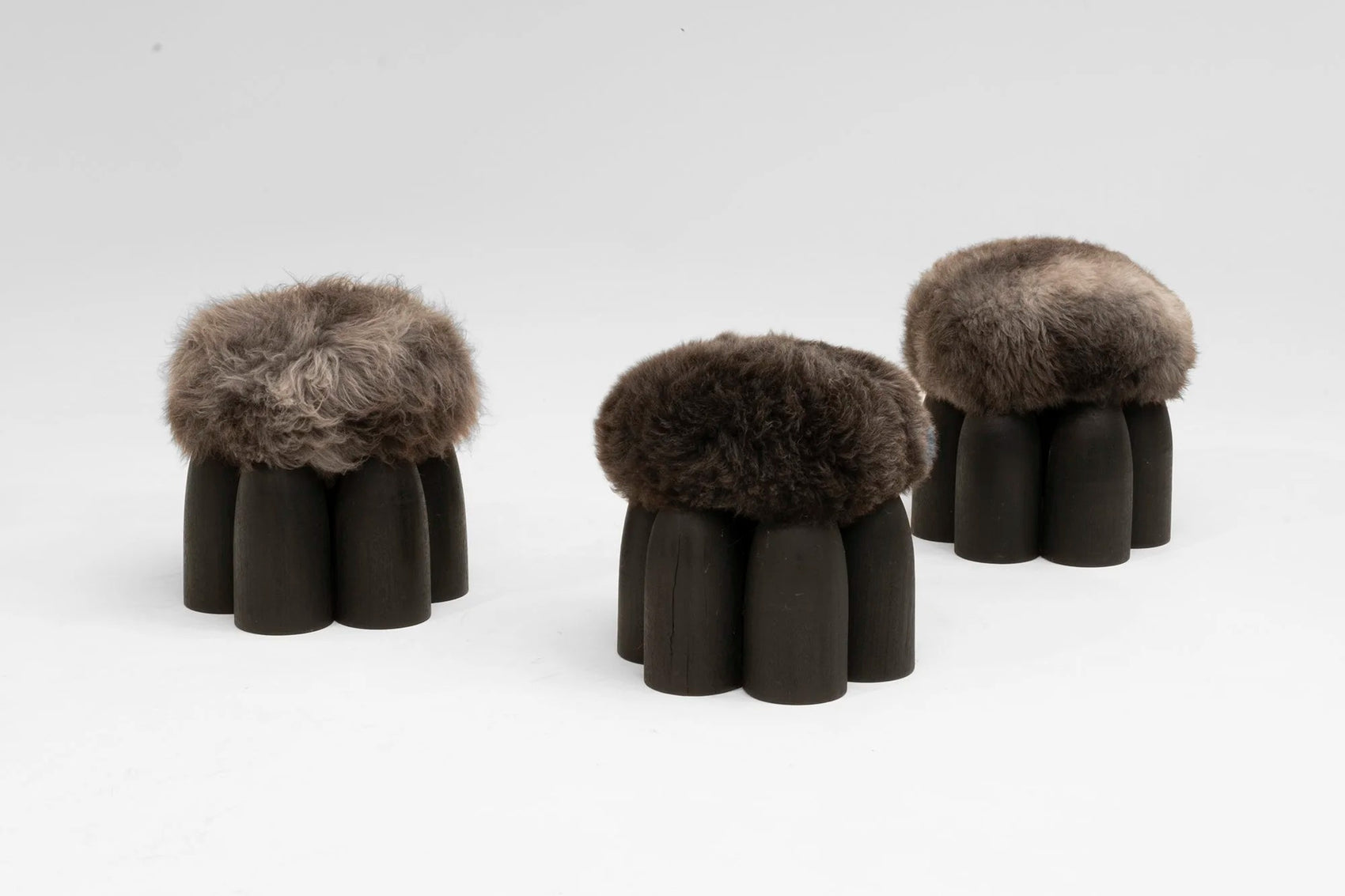Senufo Ottoman by Arno DeClercq featuring Black African Walnut and Sheep Wool, showcasing a sculptural design.