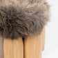 Senufo Ottoman featuring a plush sheep wool top and rounded Black African Walnut legs, designed by Arno DeClercq.