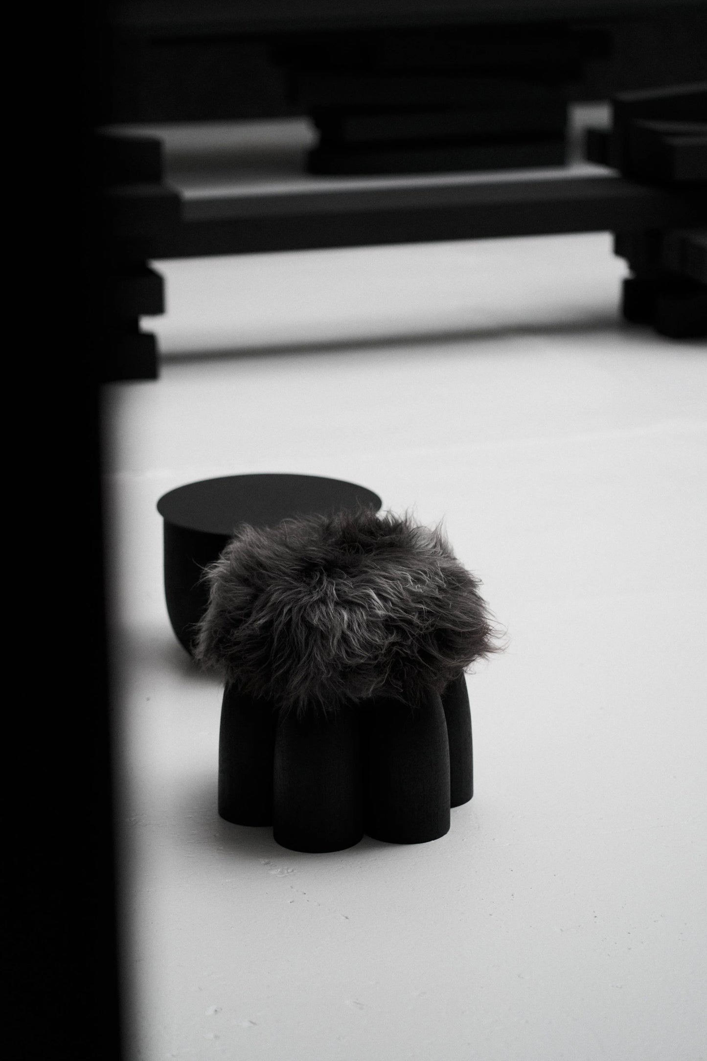 Senufo Ottoman by Arno DeClercq in Black African Walnut with Sheep Wool, showcasing a sculptural design.