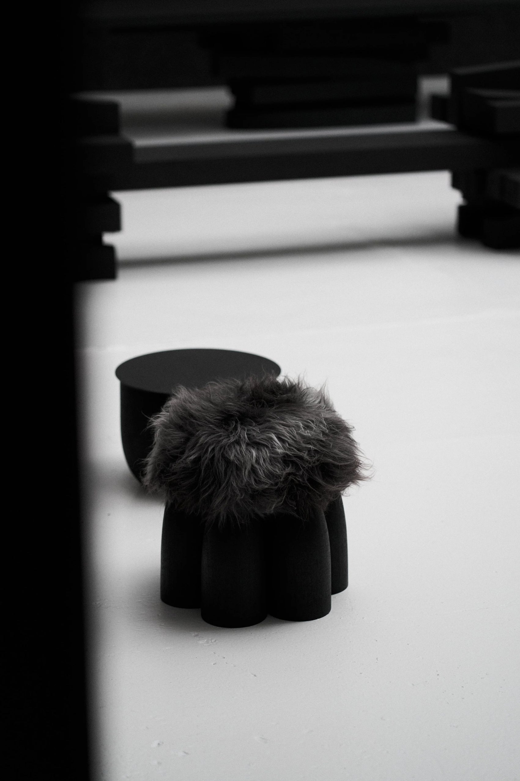 Senufo Ottoman by Arno DeClercq in Black African Walnut with Sheep Wool, showcasing a sculptural design.