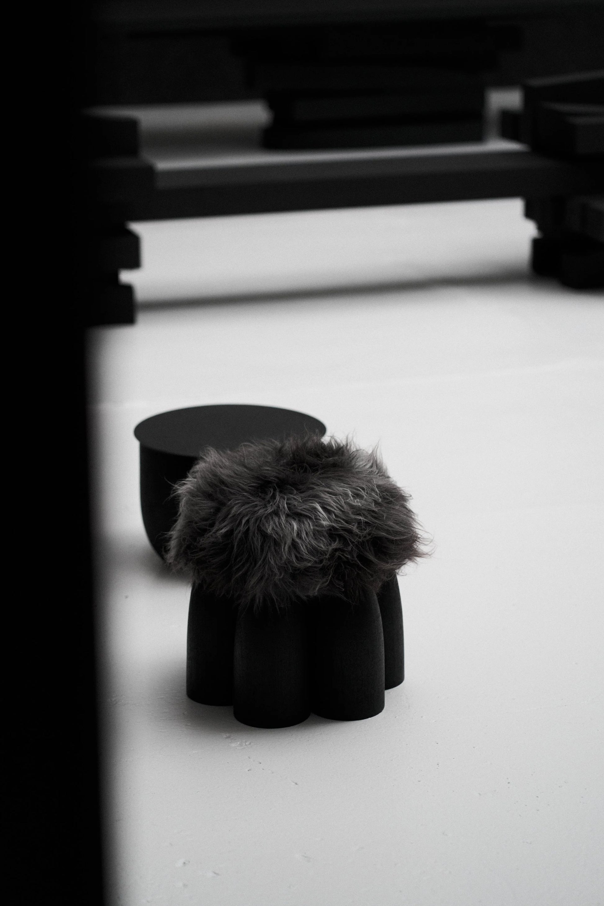 Senufo Ottoman by Arno DeClercq in Black African Walnut with Sheep Wool, showcasing a sculptural design.