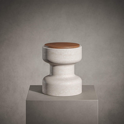 Tivoli Stool in Travertino Navona with Walnut wood top on a gray surface, in front of a gray background. 
