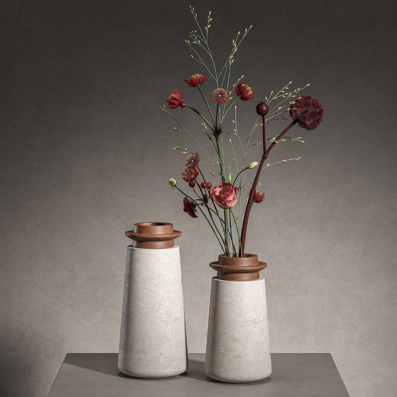 Two Tivoli vases in Travertino Navona marble with Walnut wood top. Large size (left) and Small size (right) with gray background on a gray tabletop. Small vase has red and green flowers in it that reach the top of the image. 