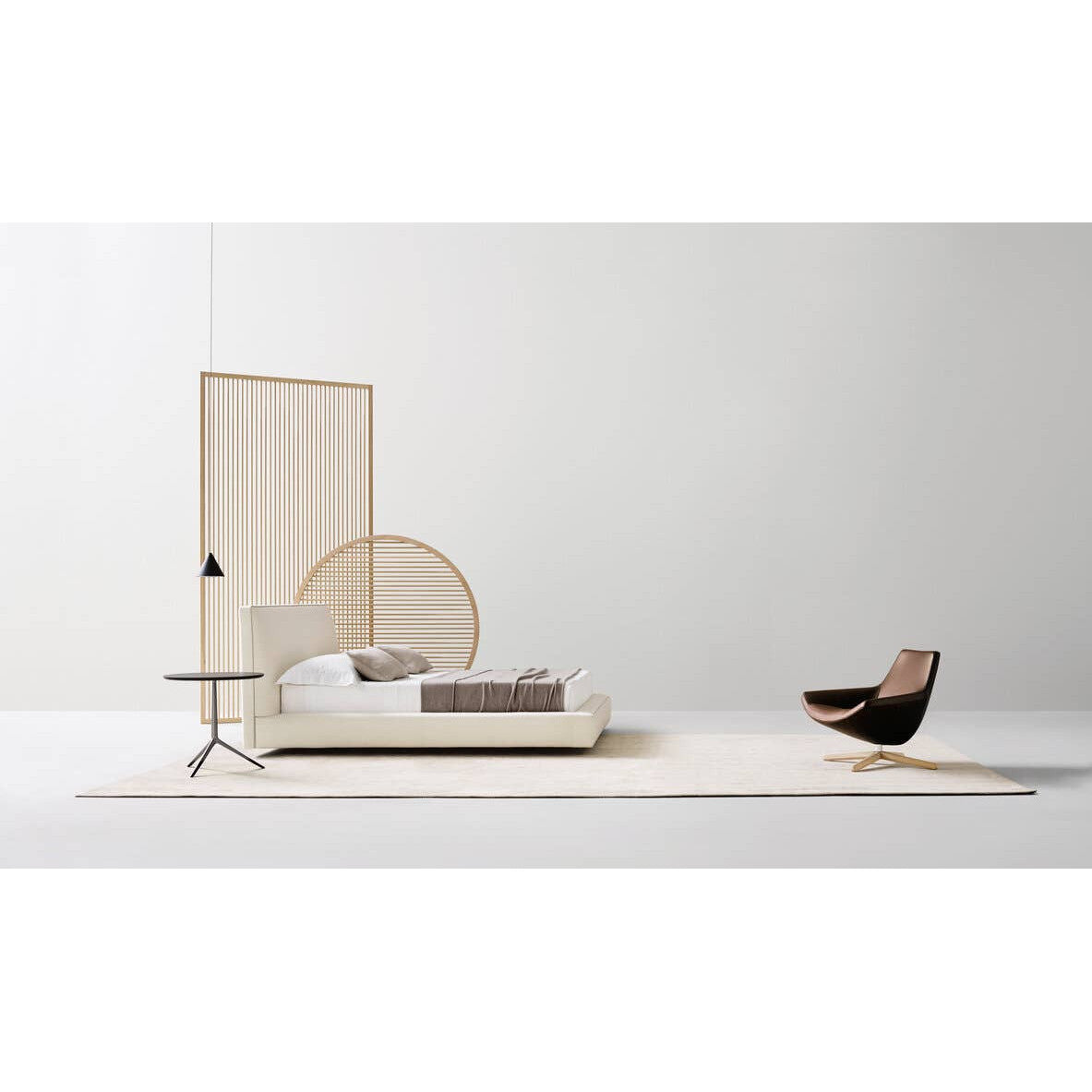 B&B Italia Richard Bed, modern designer bed in white upholstery with side table and brown leather chair, studio shot.