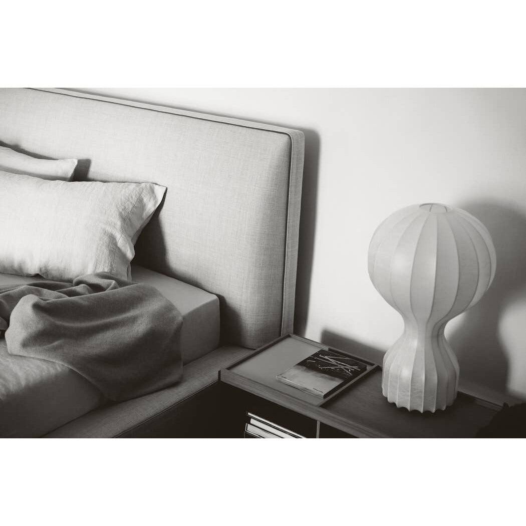 Detail of the Richard Bed headboard and bedside table with a modern sculptural glass lamp and black-and-white accents.