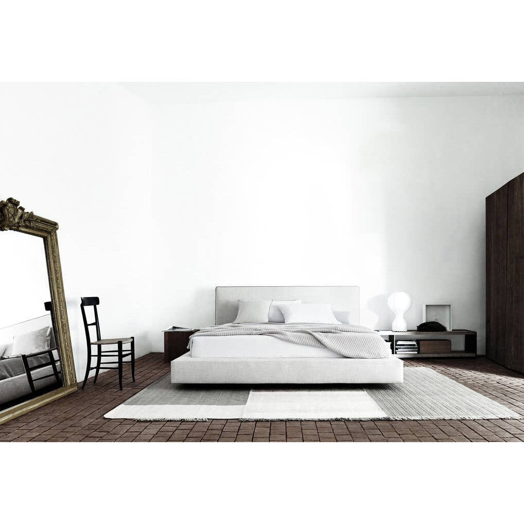 Richard Bed by B&B Italia in a bright, minimalist bedroom with an antique gold floor mirror and dark wood accents.