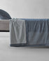 Society Limonta Nim bed sheet and pillowcase styled on a bed, featuring a casual luxury look with garment-dyed Italian cotton.